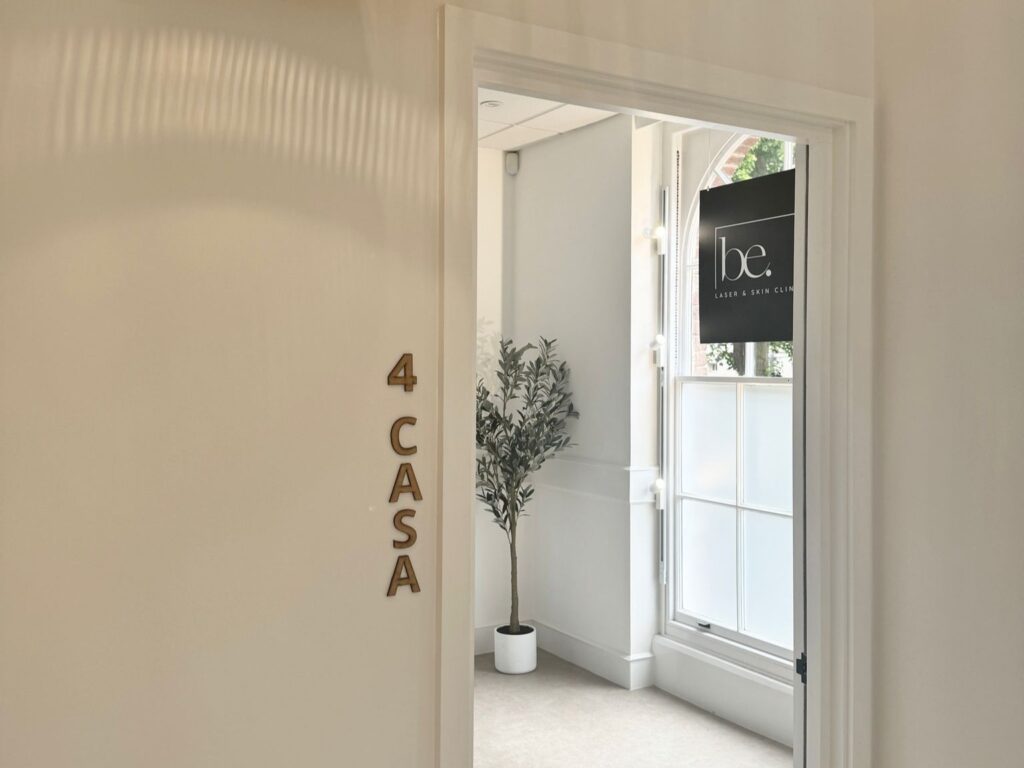 Interior view with a plant, the word CASA on a wall, and a sign for a laser and skin clinic