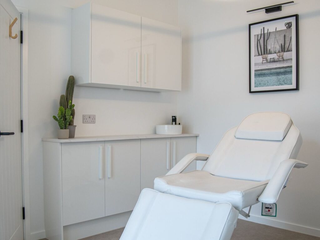 Modern white aesthetic clinic room with a treatment chair and decor