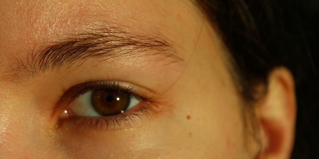 A close up of a woman's face with a brown eye