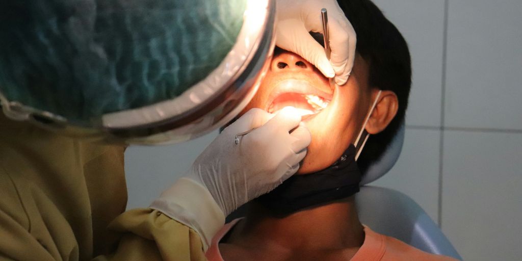 a man getting his teeth checked by a dentist