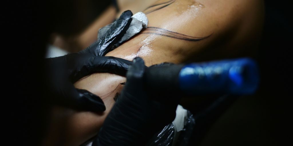 a man getting a tattoo done on his back