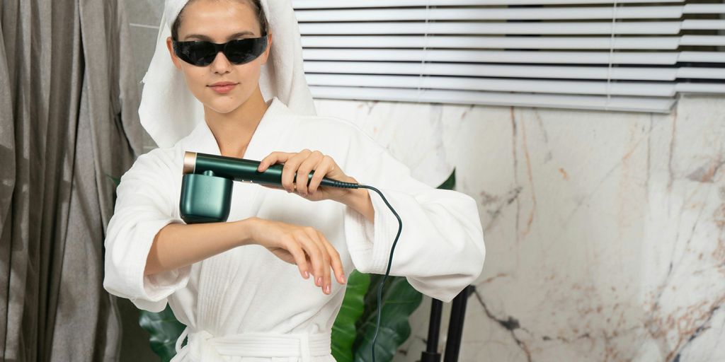 A woman in a bathrobe holding a hair dryer